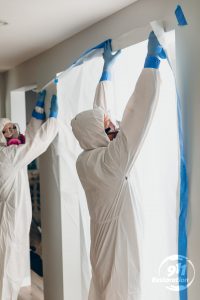 mold removal team taping off a room of a house